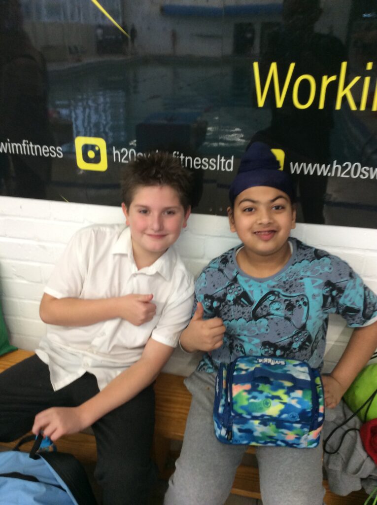 Two Milestone Academy students are seen smiling for the camera whilst at Sir Joseph Williamson's Mathematical School to take part in the LAT Swimming Gala.
