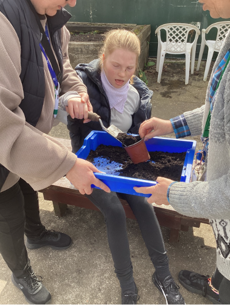 Students with a trow and dirt