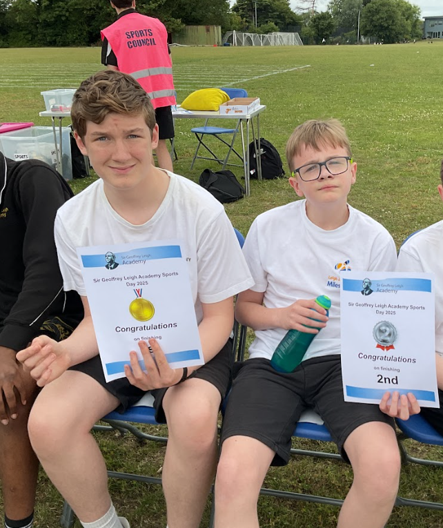 Two pupils in PE kit with sports day certificates