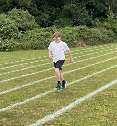 Pupil running on a grass running track