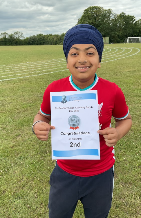 A pupil in a Liverpool football top with a sports day second place certificate