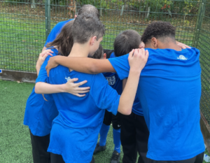 School football team wearing blue in a a team huddle
